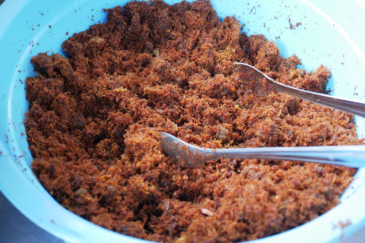 Serundeng kelapa buatan sendiri, terbuat dari kelapa parut yang disangrai dengan bumbu khas, siap dijual sebagai camilan gurih yang renyah dan lezat.